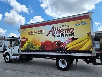 Athena Farms delivery truck offering fresh produce in a vibrant commercial area.