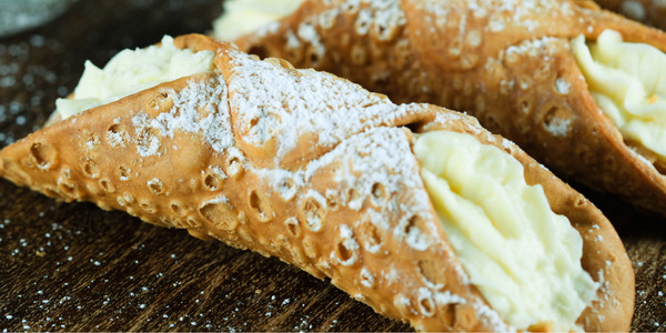 Delicious cannoli with crispy shells and creamy ricotta filling, beautifully presented on rustic wood.