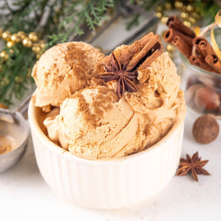 Creamy caramel ice cream with spices, nestled in a festive setting of greenery and gold.