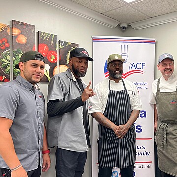 Chefs celebrate camaraderie and passion in a vibrant kitchen filled with colorful food art.