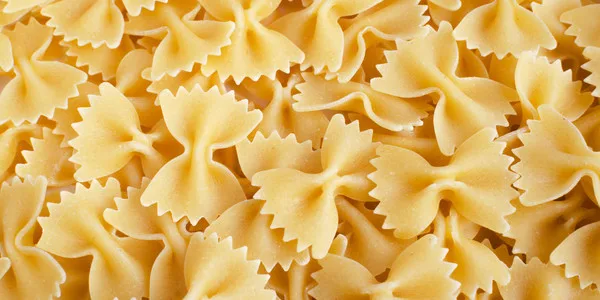 Bulk farfalle bow-tie pasta with ridged edges, ideal for wholesale food suppliers and commercial foodservice operations.