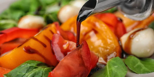 Fresh vegetables including red peppers, bell peppers, and leafy greens with oil being drizzled, ideal for wholesale food suppliers and commercial food service operations.