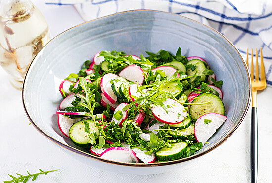Vibrant radish and cucumber salad in a blue bowl, perfect for healthy, refreshing meals.