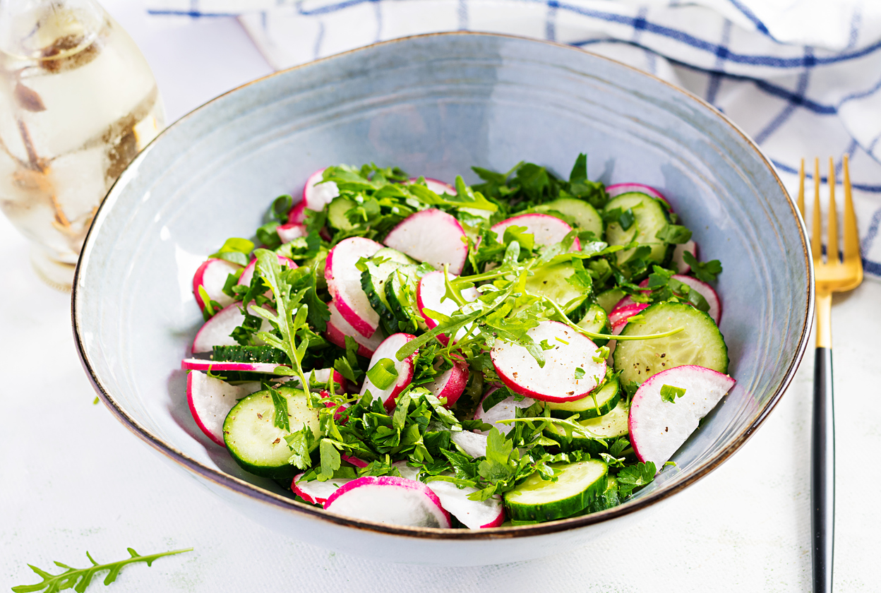 Vibrant radish and cucumber salad in a blue bowl, perfect for healthy, refreshing meals.
