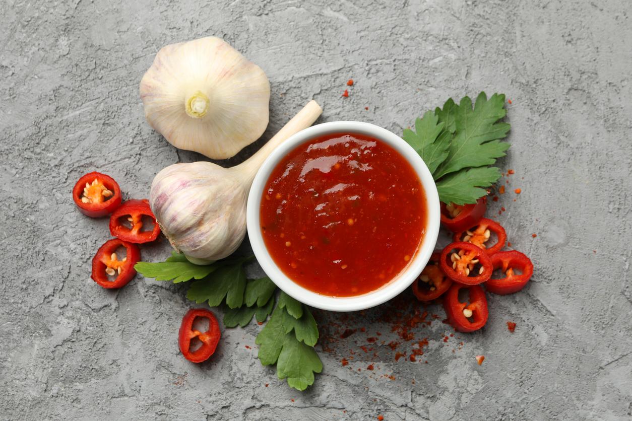 Bowl With Chilli Sauce, Pepper And Garlic On Gray Background