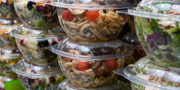Vibrant pasta and garden salads displayed in clear containers for convenient, healthy meals.